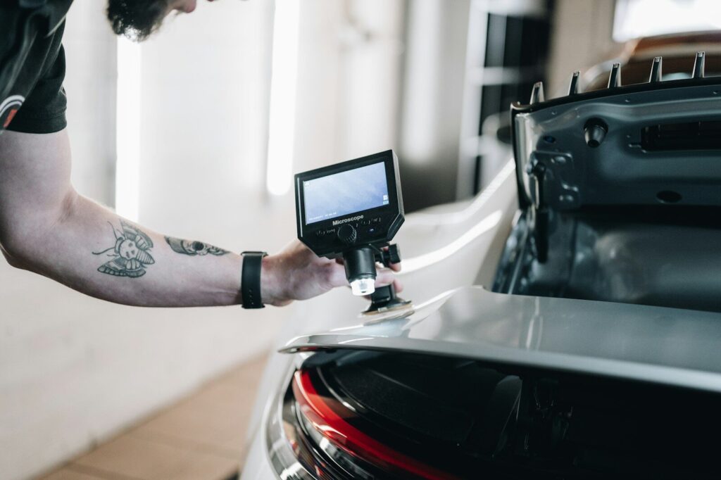 a man with a tattoo on his arm working on a car